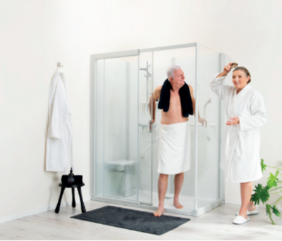 Een oudere vrouw en man die bij hun KINEMAGIC douche staan.